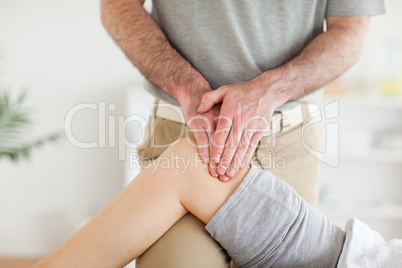 Chiropractor massaging a charming woman's knee