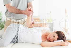 Chiropractor stretches a customer's arm