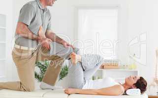 Chiropractor stretching woman's leg