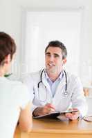 Smiling Doctor talking to a brunette patient