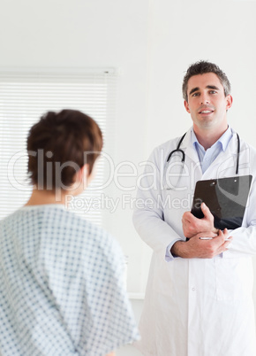 Doctor talking to a charming woman in hospital gown