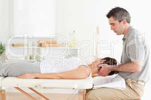 Masseur stretching woman's head