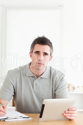 Doctor sitting working with a tablet and a chart