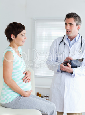 Sitting Pregnant woman touching her belly