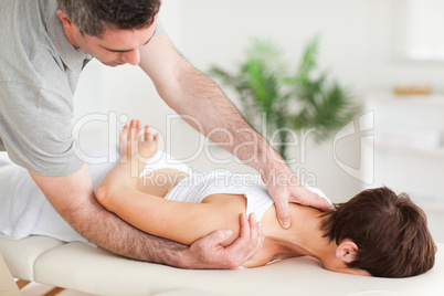 Chiropractor stretching a woman's shoulder