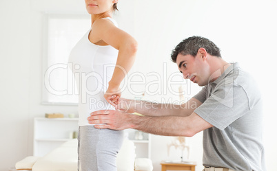 Chiropractor examining a cute woman's back