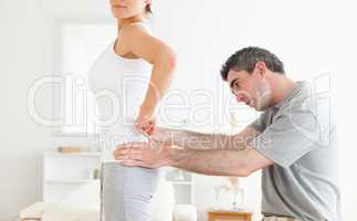 Chiropractor examining a cute woman's back