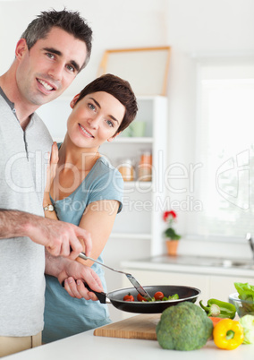 Gorgeous Woman and her pan-holding husband looking into the came