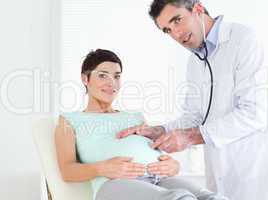 Doctor examining a tummy with a stethoscope