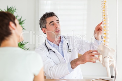 Doctor showing a woman a part of a spine