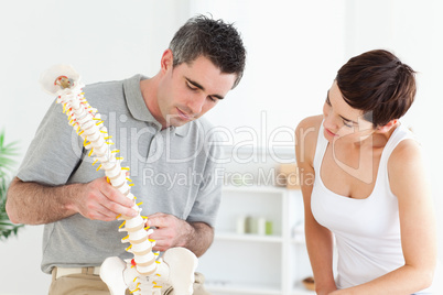 Chiropractor and patient looking at a model of a spine