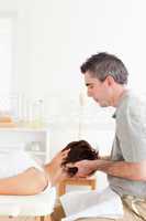 Chiropractor stretches customer's neck