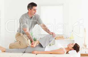 Chiropractor stretching a female customer's leg