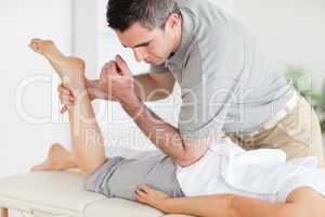 Chiropractor stretches a woman's leg