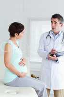 Sitting Pregnant woman talking to her doctor