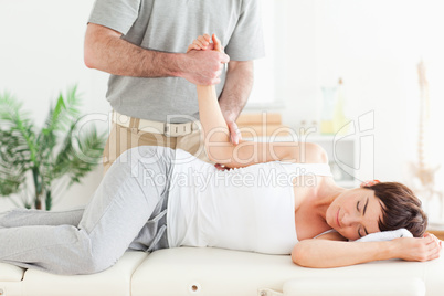 Chiropractor stretches a woman's arm