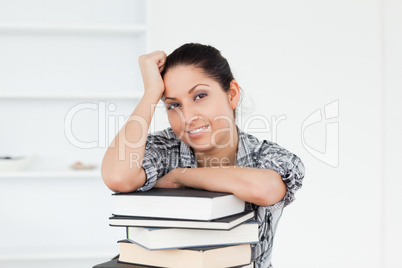 A young student is leaning on books