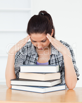 Frustrated young student leaning on books