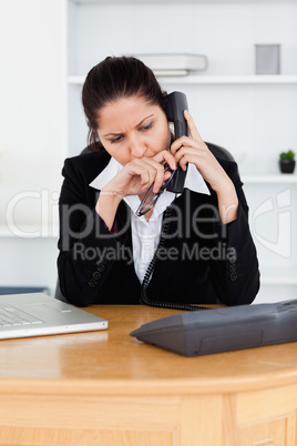 Dissatisfied businesswoman telephoning in office