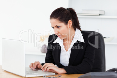 Young businesswoman focused on laptop screen