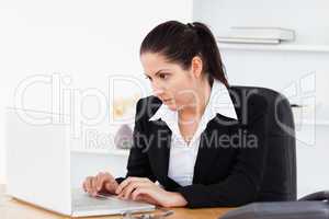 Young businesswoman focused on laptop screen