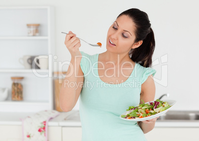 Casual young woman eating salad