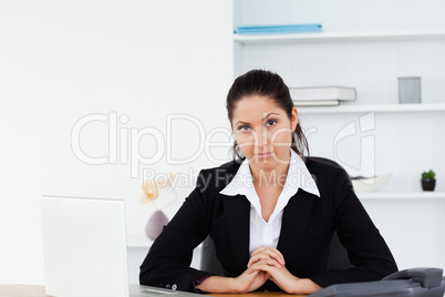 Serious businesswoman sitting at workplace