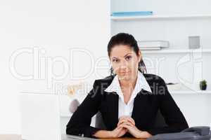 Serious businesswoman sitting at workplace