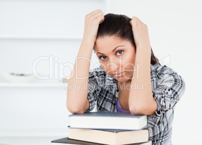 Tired young student resting on books