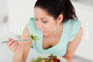 Beautiful young woman eating salad