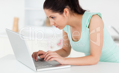Young woman at her laptop in kitchen