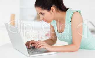 Young woman at her laptop in kitchen