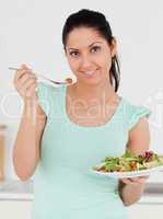 Young woman with salad looking to camera