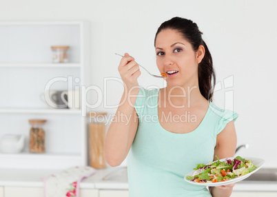 Lovely young woman with salad in kitchen