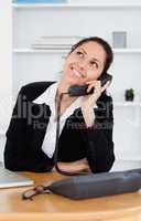 Cheerful cute businesswoman telephoning