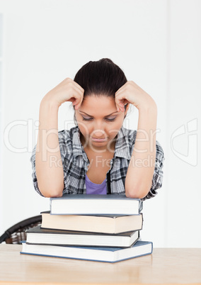 Frustrated young student resting on books