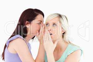 Portrait of a young woman telling her friend a secret
