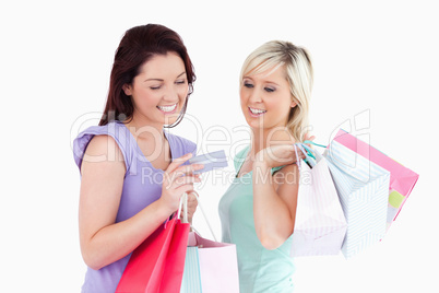 Cheerful women with shopping bags and a card