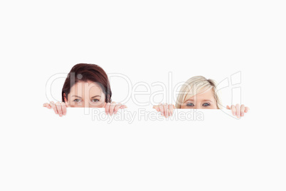 Women peeking over a banner