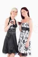 Smiling well-dressed women drinking red wine