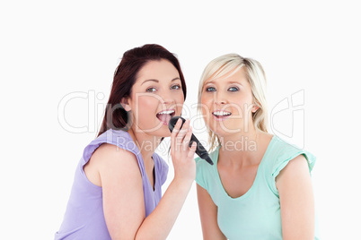 Cheerful Women singing karaoke