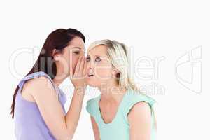 Portrait of a cute woman telling her friend a secret