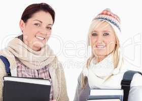 Two female students with books looking