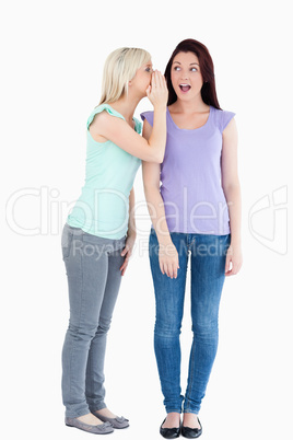 Beautiful woman telling her friend a secret