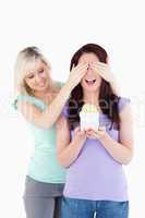 Young woman  giving a gift to her friend