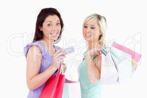 Charming women with shopping bags and a card