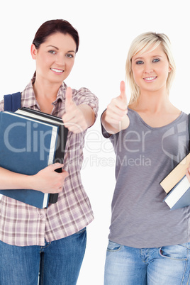 Students with books and thumbs up