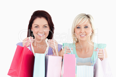 Cheerful young women with shopping bags