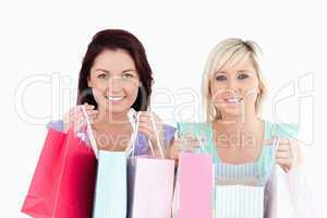 Cheerful young women with shopping bags