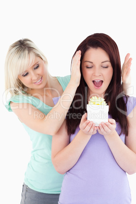 Young woman  giving a gift to her friend